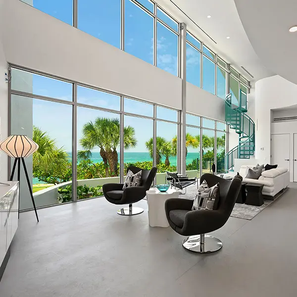 Contemporary waterfront home staging in Casey Key Florida featuring double height living room, floor to ceiling windows, and Gulf views