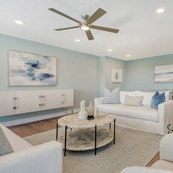Coastal contemporary condo staging in Lido Key Florida featuring light-filled living room, soft blue tones, modern furnishings, and open layout