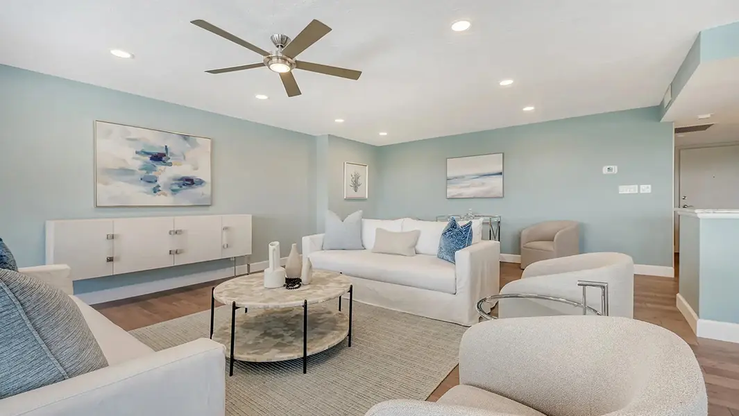 Coastal contemporary condo staging in Lido Key Florida featuring light-filled living room, soft blue tones, modern furnishings, and open layout