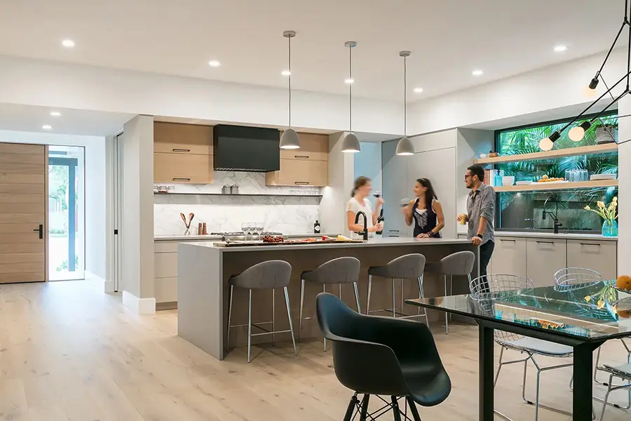 Contemporary home staging in Sarasota Florida featuring modern kitchen with island seating, pendant lighting, and open dining area