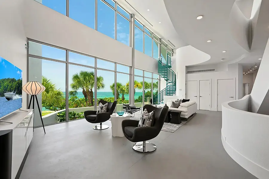 Contemporary waterfront home staging in Casey Key Florida featuring double height living room, floor to ceiling windows, and Gulf views