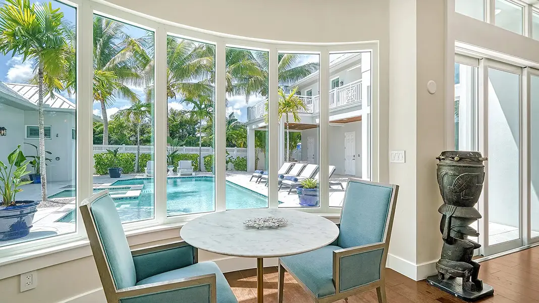 Luxury home staging in Sarasota featuring pool view through large windows and bright coastal interior