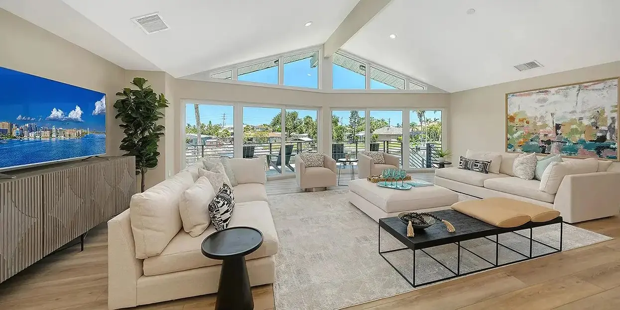Modern coastal home staging in Siesta Key Florida featuring bright living room, vaulted ceilings, and waterfront views