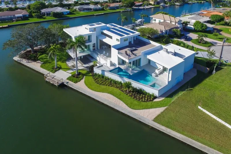 Aerial view of modern waterfront luxury home with pool and rooftop terrace in Longboat Key