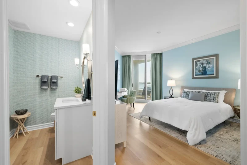Coastal bedroom and bathroom home staging with soft blue palette, modern furnishings, and balcony views in Sarasota condo interior