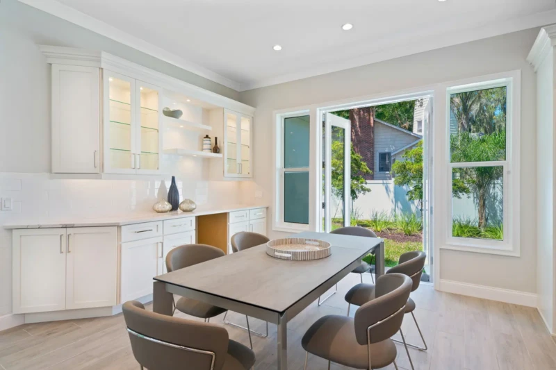Coastal contemporary dining room staging with indoor-outdoor living in Sarasota luxury spec home