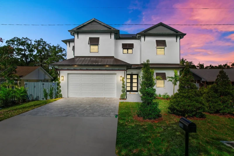Coastal contemporary home in Sarasota’s East of the Trail neighborhood with modern architecture, twilight exterior lighting, and luxury curb appeal