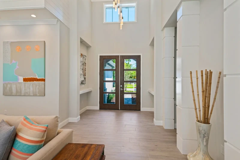 Coastal contemporary home entryway staging with soaring ceilings in Sarasota luxury spec home