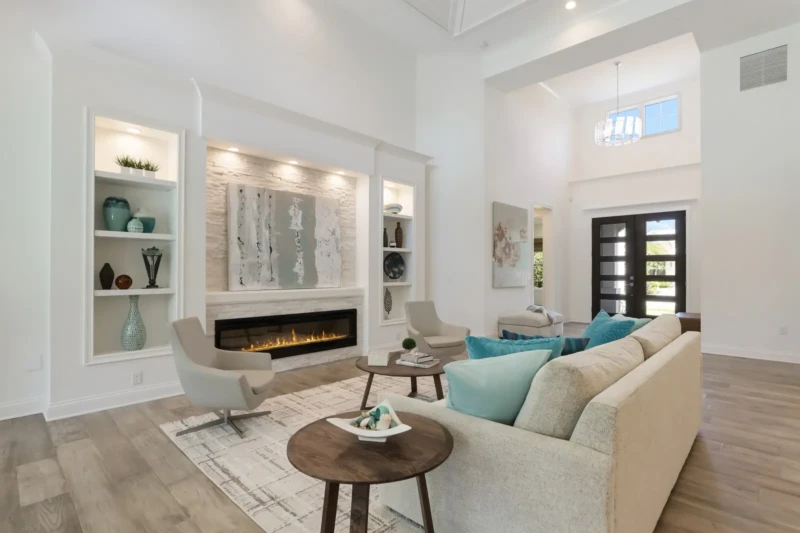 Coastal contemporary living room staging with fireplace and vaulted ceilings in West of Trail Sarasota home