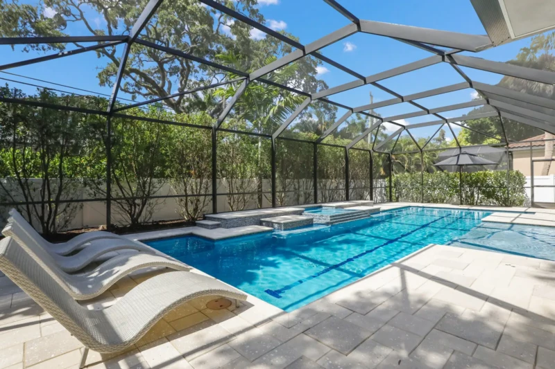 Luxury screened pool and spa area at coastal contemporary Sarasota home staged by iStage Homes