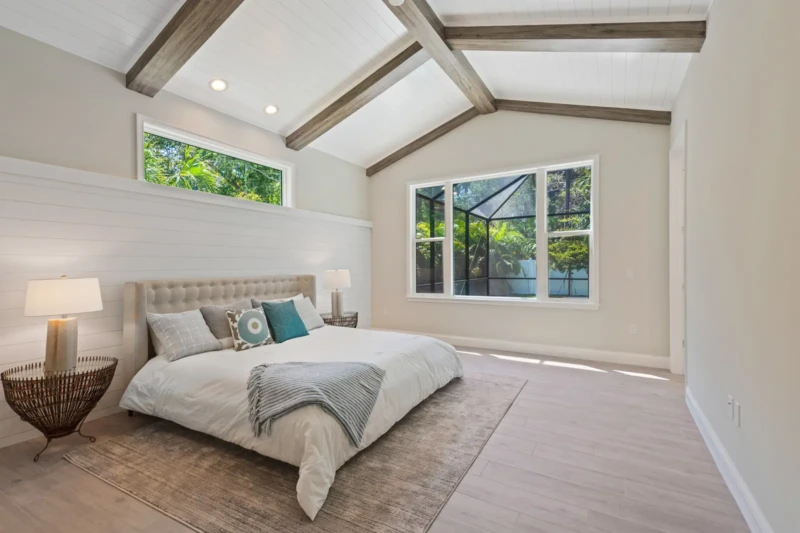 Coastal contemporary primary bedroom staging with vaulted ceilings in Sarasota luxury spec home