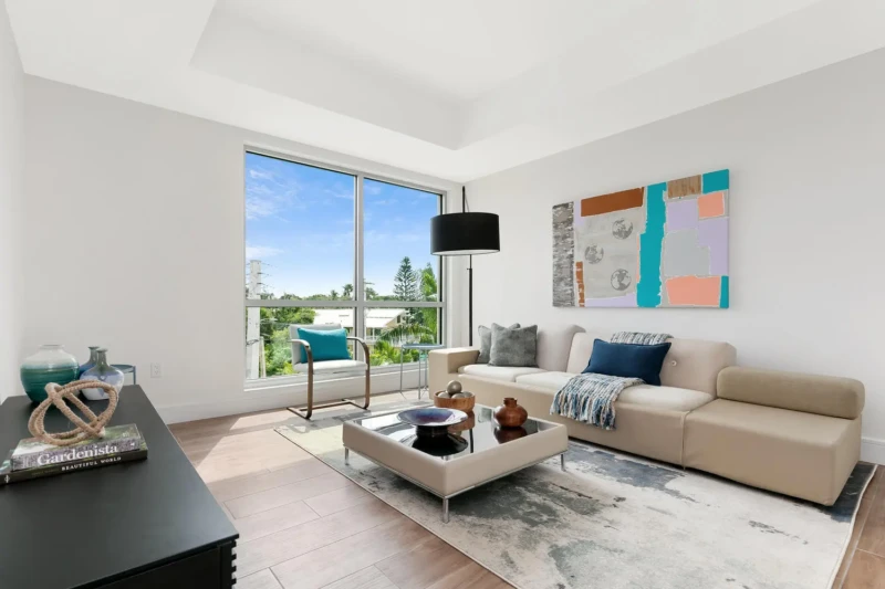 Coastal contemporary sitting room staging on Siesta Key with modern furnishings, soft neutral tones, and natural light in a luxury waterfront condominium
