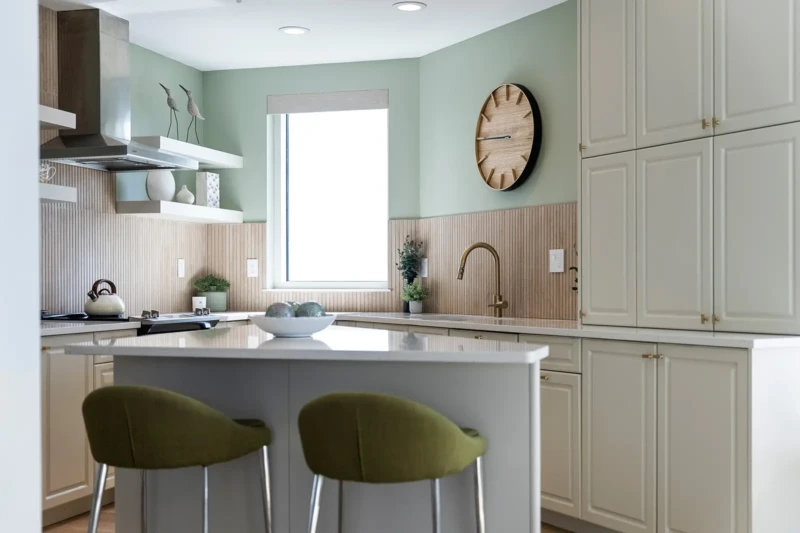 Coastal kitchen home staging with soft green accents, custom cabinetry, and modern finishes in Sarasota home