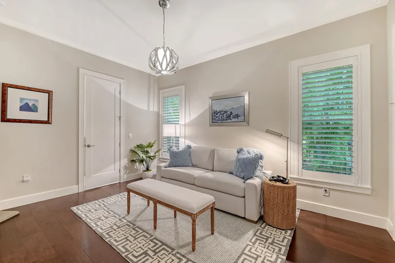 Coastal contemporary sitting room staging with neutral furnishings and tropical light