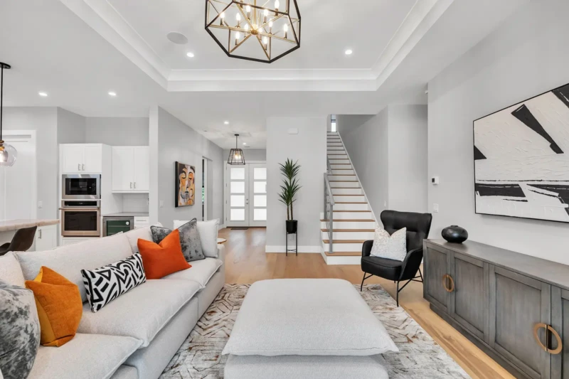 Contemporary great room staging in East of the Trail Sarasota home with open-concept layout, modern staircase, neutral furnishings, and luxury interior design
