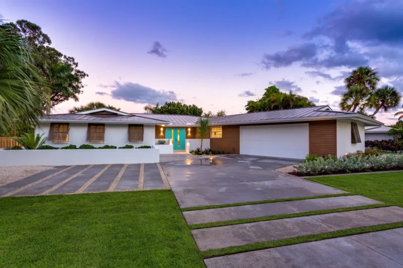Contemporary home exterior staging at dusk in Bird Key Sarasota with modern landscaping and coastal architecture