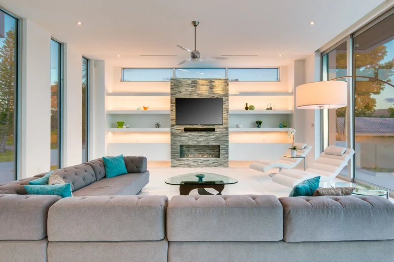 Contemporary luxury living room staging in Sarasota with custom fireplace wall, modern sectional seating, and floor-to-ceiling windows in a waterfront home interior