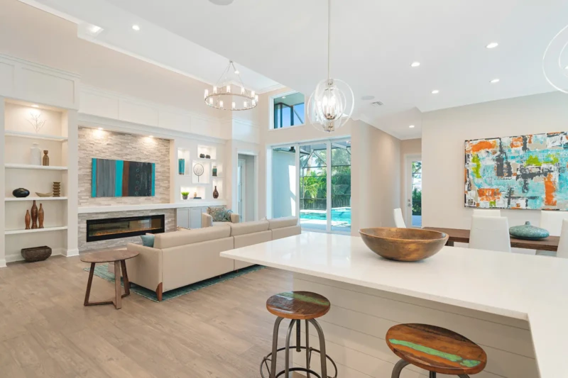 Contemporary great room and kitchen staging with pool views in Paradise Shores West of Trail Sarasota home
