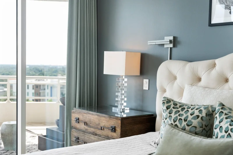 Luxury bedroom detail with tufted headboard, modern lighting, and soft coastal styling in Sarasota condo staging