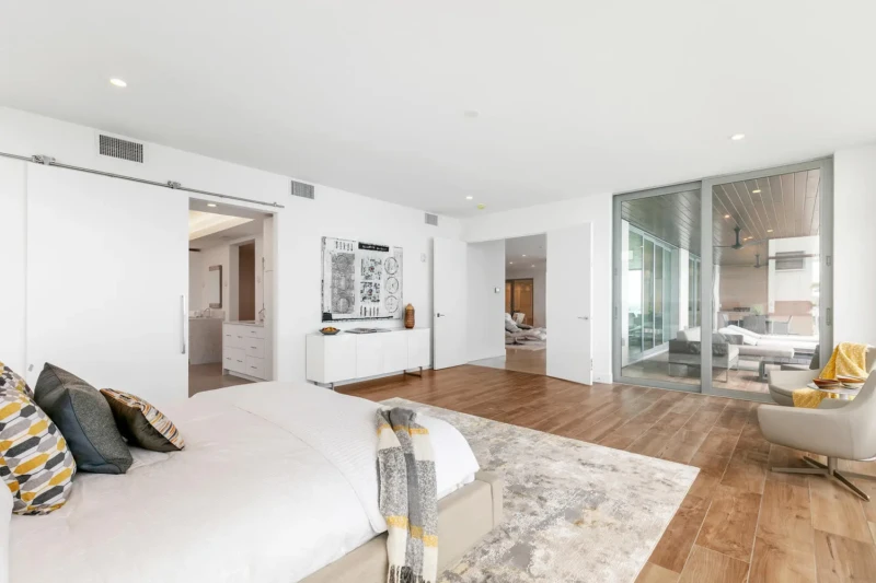 Luxury waterfront bedroom suite staging on Siesta Key with expansive layout, private terrace access, and contemporary coastal interiors overlooking the Gulf of Mexico