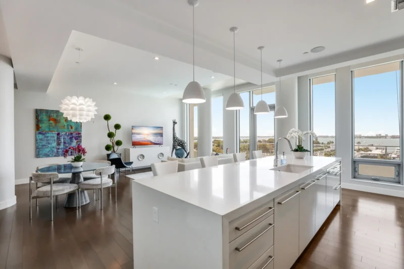 Luxury condo kitchen staging with bay views at The Jewel Sarasota featuring modern white island and open-concept design