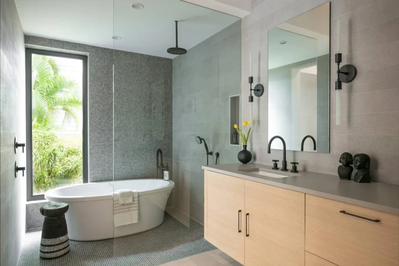 Luxury modern bathroom home staging in Sarasota featuring a freestanding soaking tub, spa-inspired design, and contemporary wood vanity with matte black fixtures