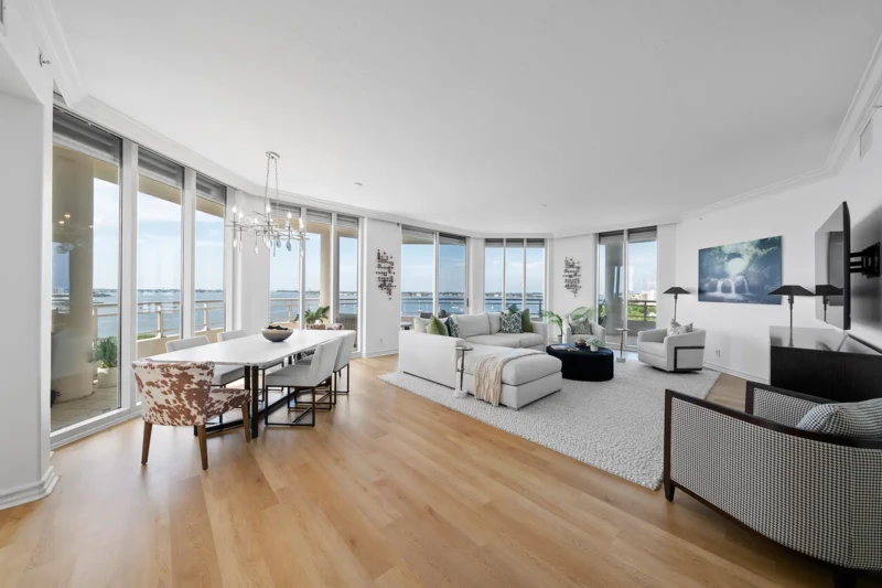 Luxury waterfront condo living and dining room staging with panoramic bay views in Sarasota