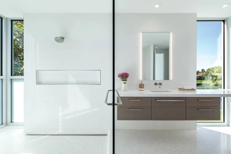 Minimalist luxury bathroom with glass shower and floating vanity in modern Longboat Key waterfront home