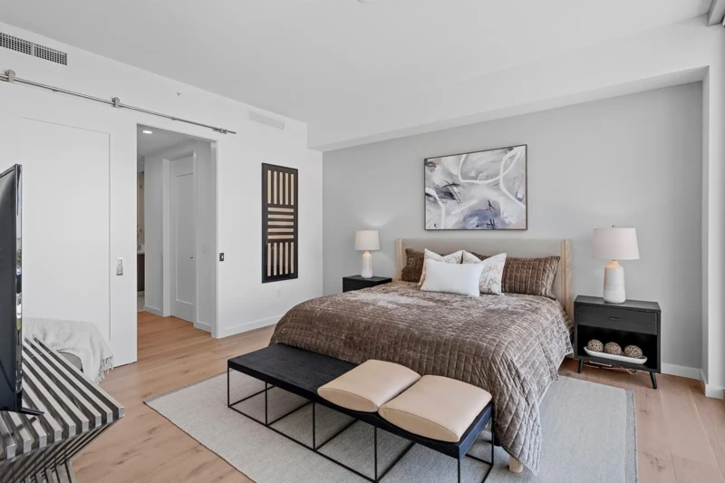 Modern condo bedroom staging with neutral furnishings and contemporary artwork