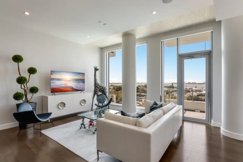 Modern condo living room staging with bay views at The Jewel Sarasota luxury residence