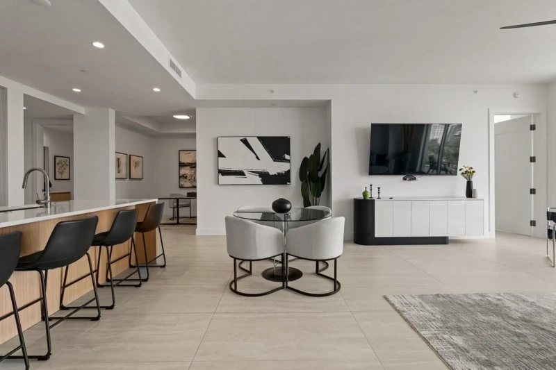 Modern open-concept condo staging with contemporary kitchen, dining area, and minimalist furnishings in Sarasota luxury residence