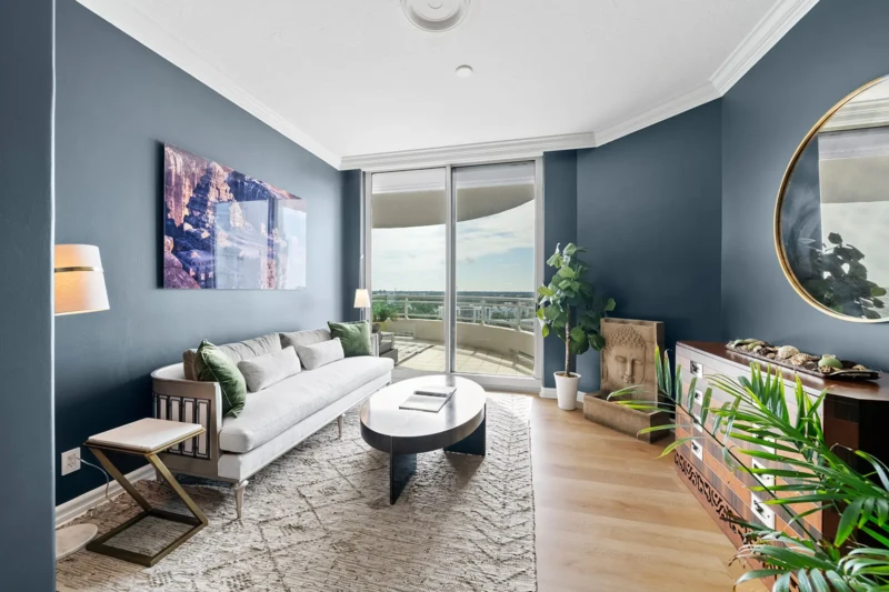 Modern den home staging with deep blue walls, balcony views, and contemporary furnishings in Sarasota luxury condo interior