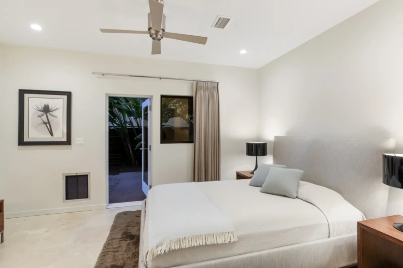 Modern guest bedroom staging with patio access