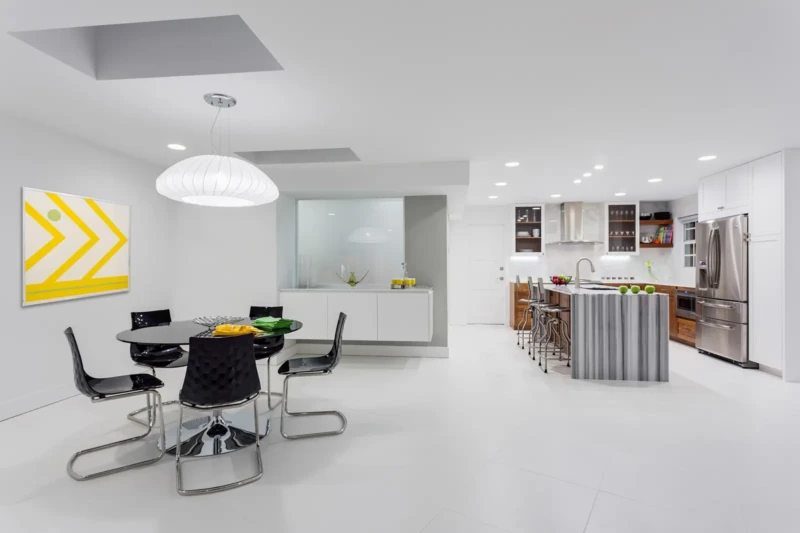 Modern kitchen and dining room staging in Bird Key Sarasota with white interiors, sculptural island, and contemporary furnishings