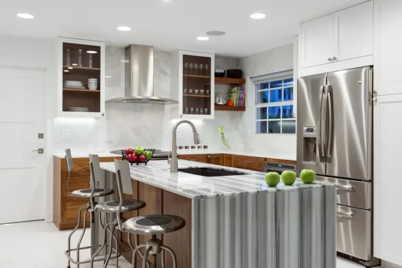 Modern kitchen island staging in Bird Key Sarasota with waterfall countertop, wood cabinetry, and contemporary bar seating