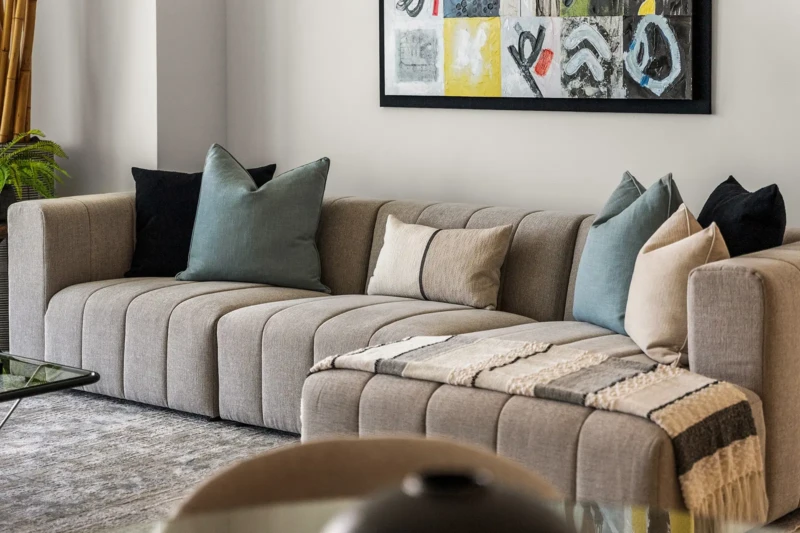 Modern living room detail featuring luxury sectional seating, layered textiles, and contemporary décor in Sarasota condo staging