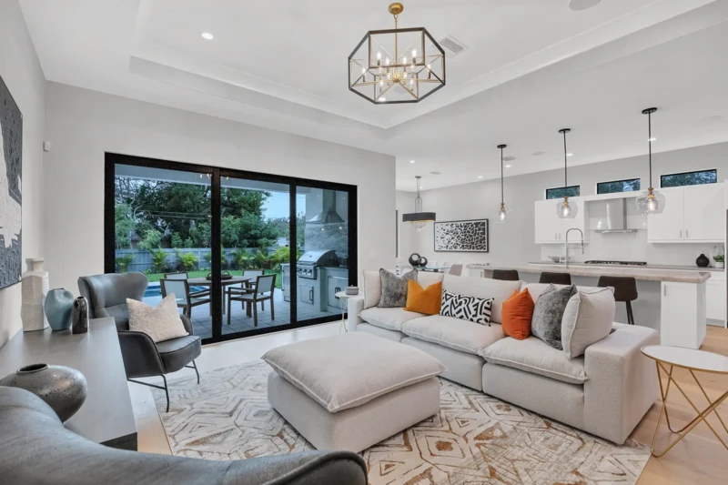 Modern living room and kitchen staging in East of the Trail Sarasota home featuring contemporary furnishings, open-concept design, and seamless indoor-outdoor living spaces