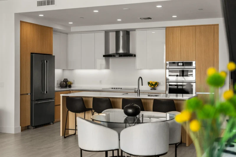 Modern luxury condo kitchen staging with minimalist cabinetry, waterfall island, and contemporary dining area in Sarasota waterfront residence