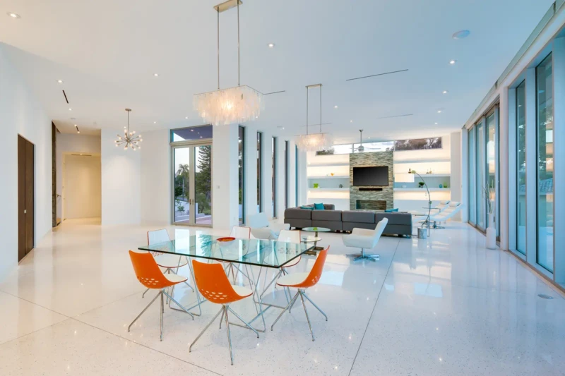 Modern open-concept living and dining room staging in Sarasota luxury waterfront home with floor-to-ceiling glass, contemporary furnishings, and expansive interiors