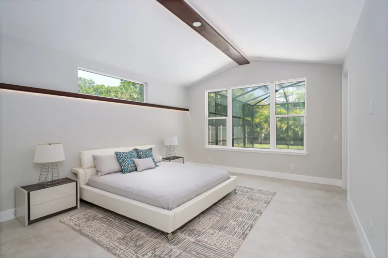 Modern primary bedroom staging with vaulted ceiling in Sarasota luxury spec home