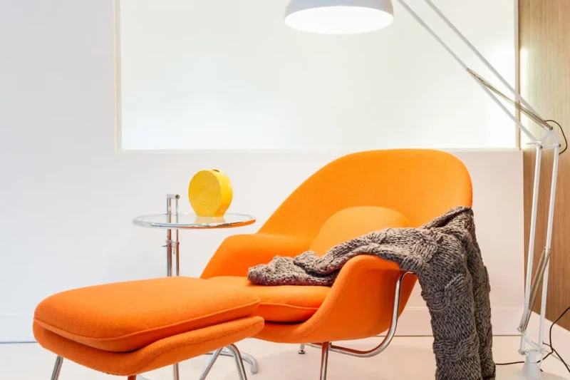 Modern reading nook staging in Bird Key Sarasota featuring an orange lounge chair, floor lamp, and contemporary minimalist design