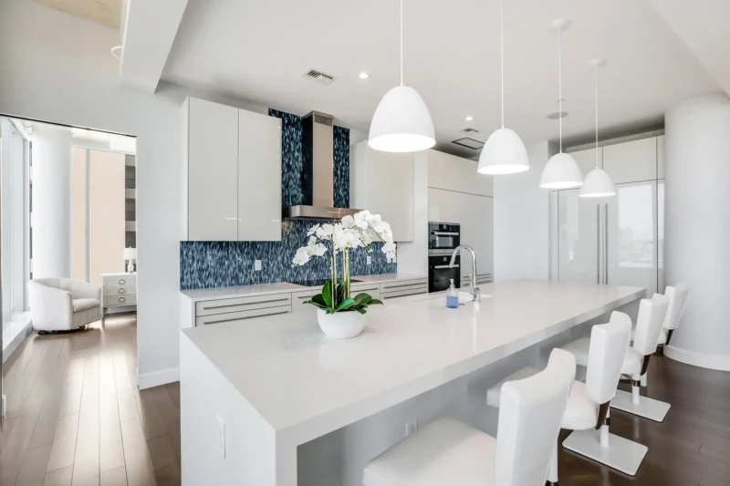 Modern white luxury condo kitchen staging at The Jewel Sarasota with waterfall island and contemporary lighting