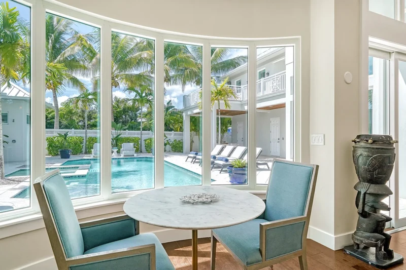 Poolside breakfast nook staging with tropical views and contemporary coastal design