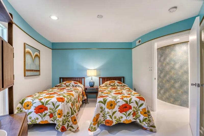 Twin guest bedroom with retro floral bedding in Sarasota Round House