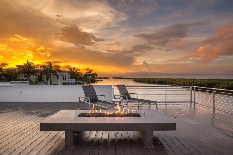 Sunset rooftop terrace with modern fire pit overlooking Sarasota Bay in Longboat Key luxury home