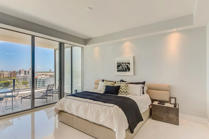 Luxury condo bedroom staging with balcony access at The VUE Sarasota