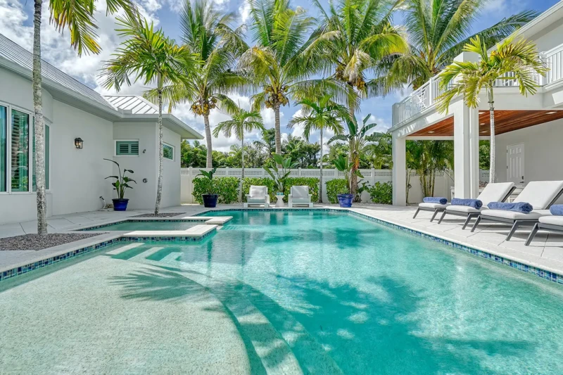 Tropical luxury poolside staging with resort-style lounge area and palm trees