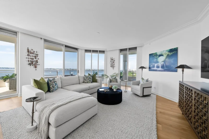 Waterfront condo living room staging with floor-to-ceiling windows and bay views in Sarasota