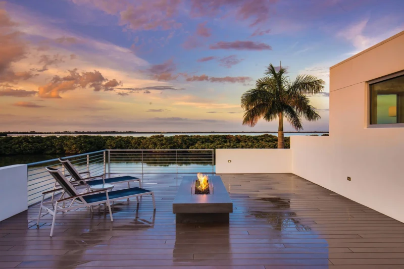 Waterfront rooftop deck with fire pit and sunset bay views in Longboat Key modern luxury home